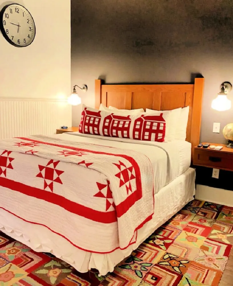 bedroom-with-colorful-carpet-and-red-white-bed-linens