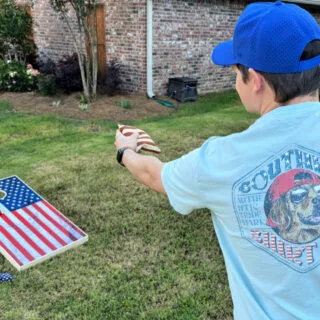 man-playing-corn-hole-in-yard-fathers-day-gifts